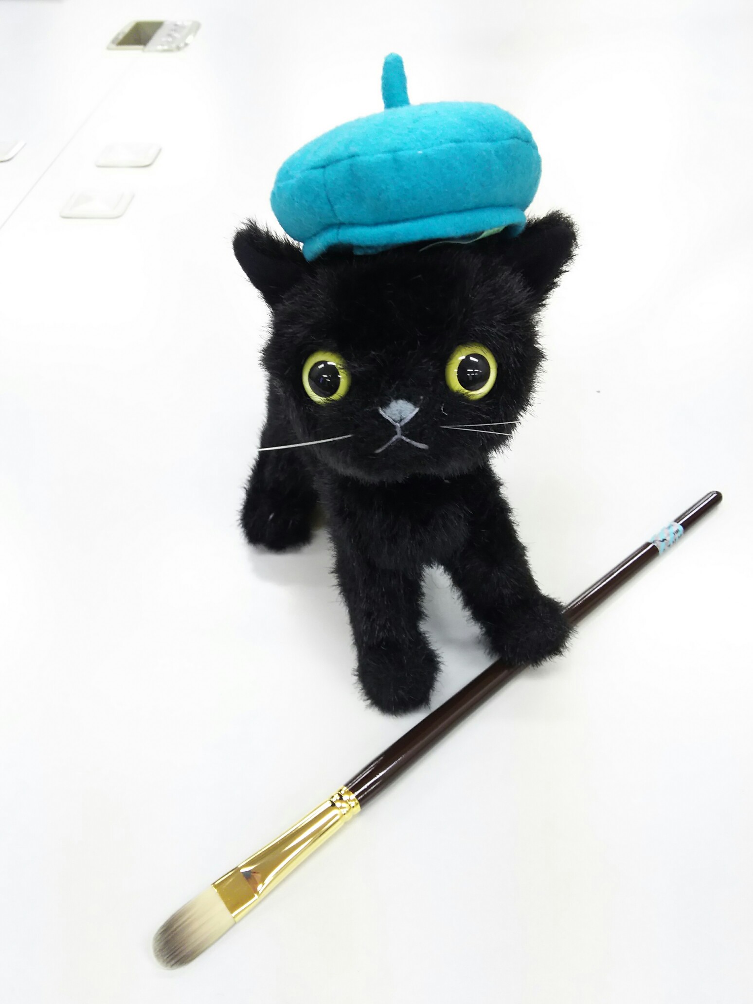 黒猫が絵筆をもっている